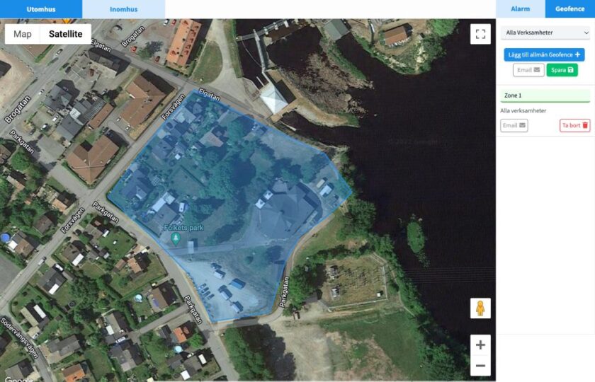 Satellitbild över ett område med byggnader och vägar, med en blåmarkerad geofence-zon vid Folkets park.